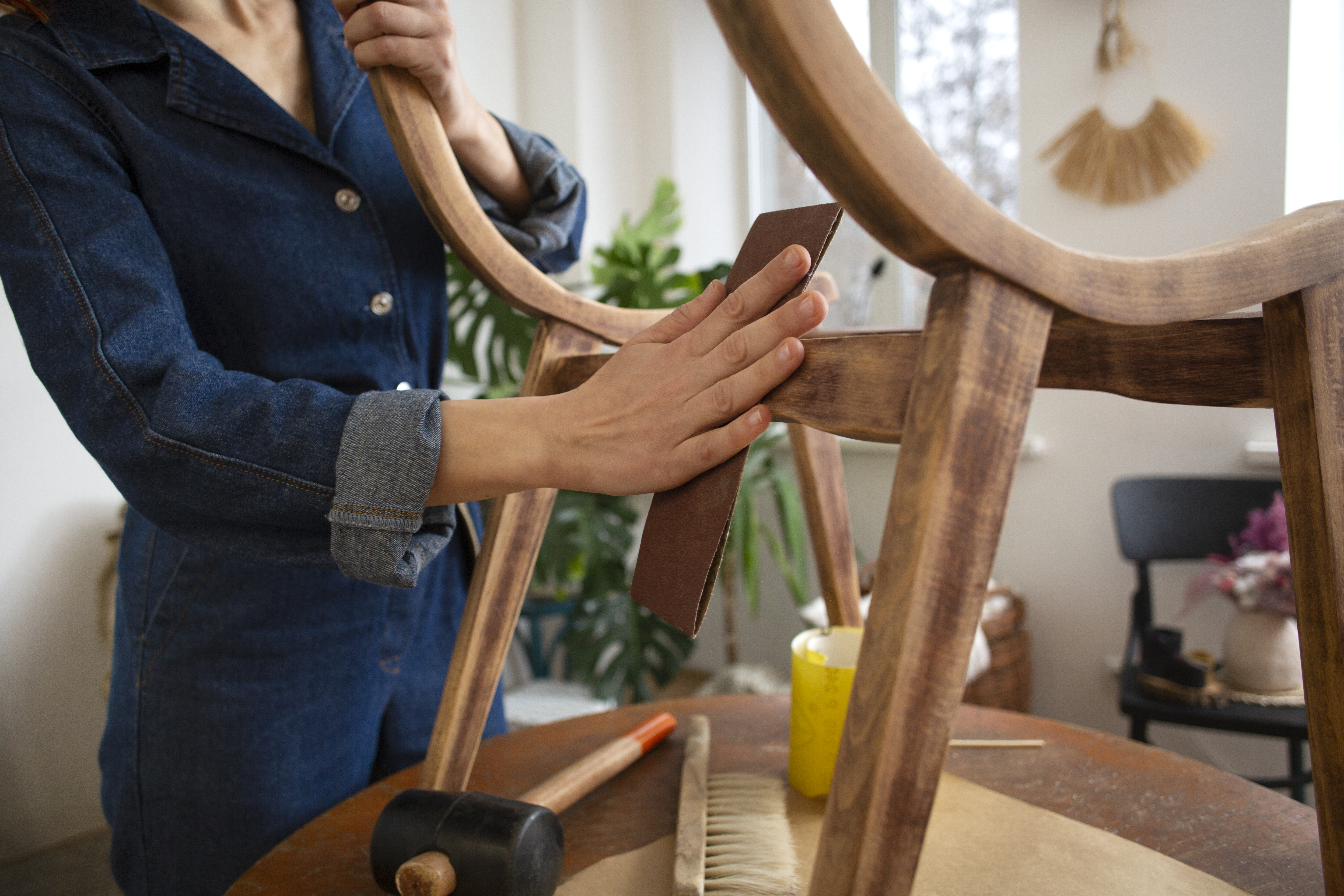 esta imagen muestra una mujer restaurando un mueble